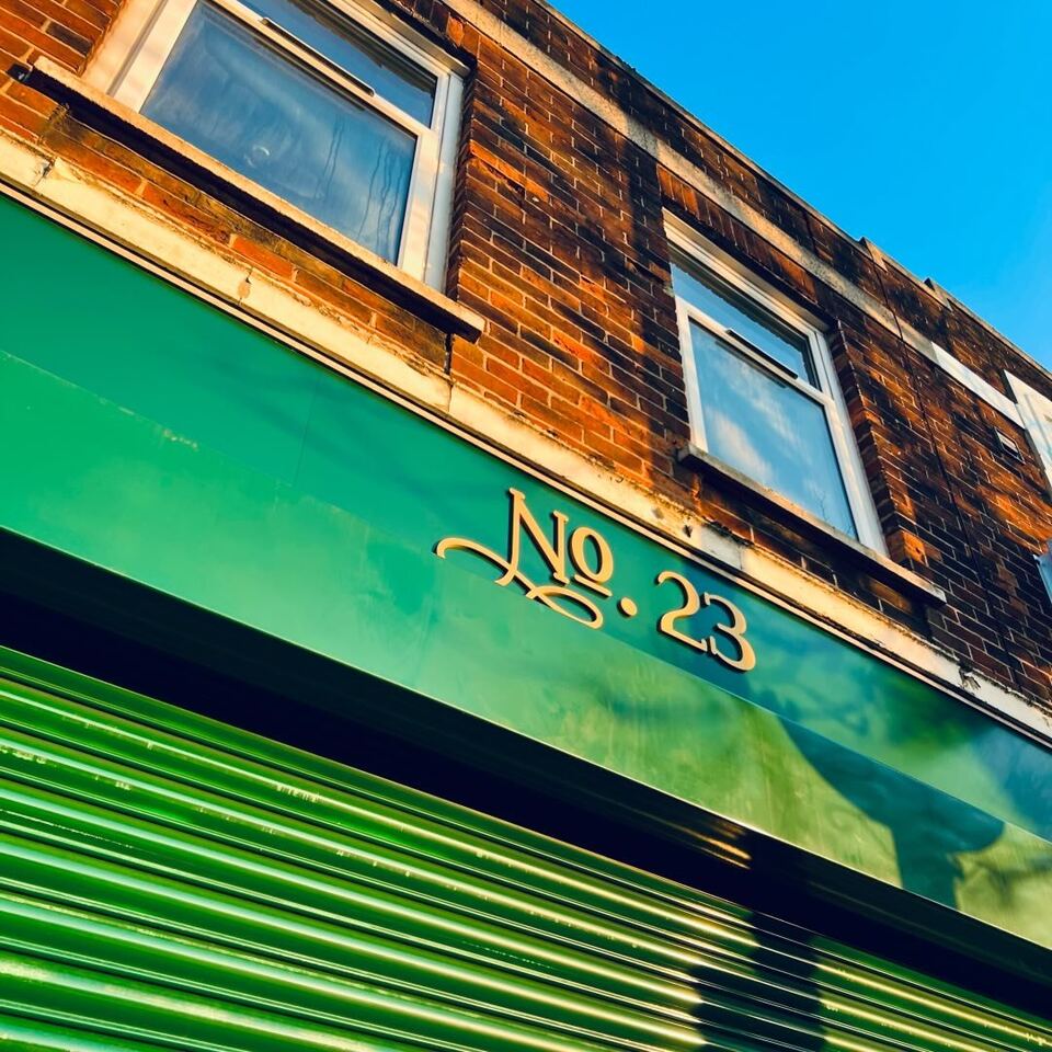 The green No.23 shopfront with its name in gold lettering